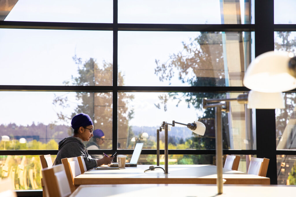 Student sitting at table on the University of Washington campus.