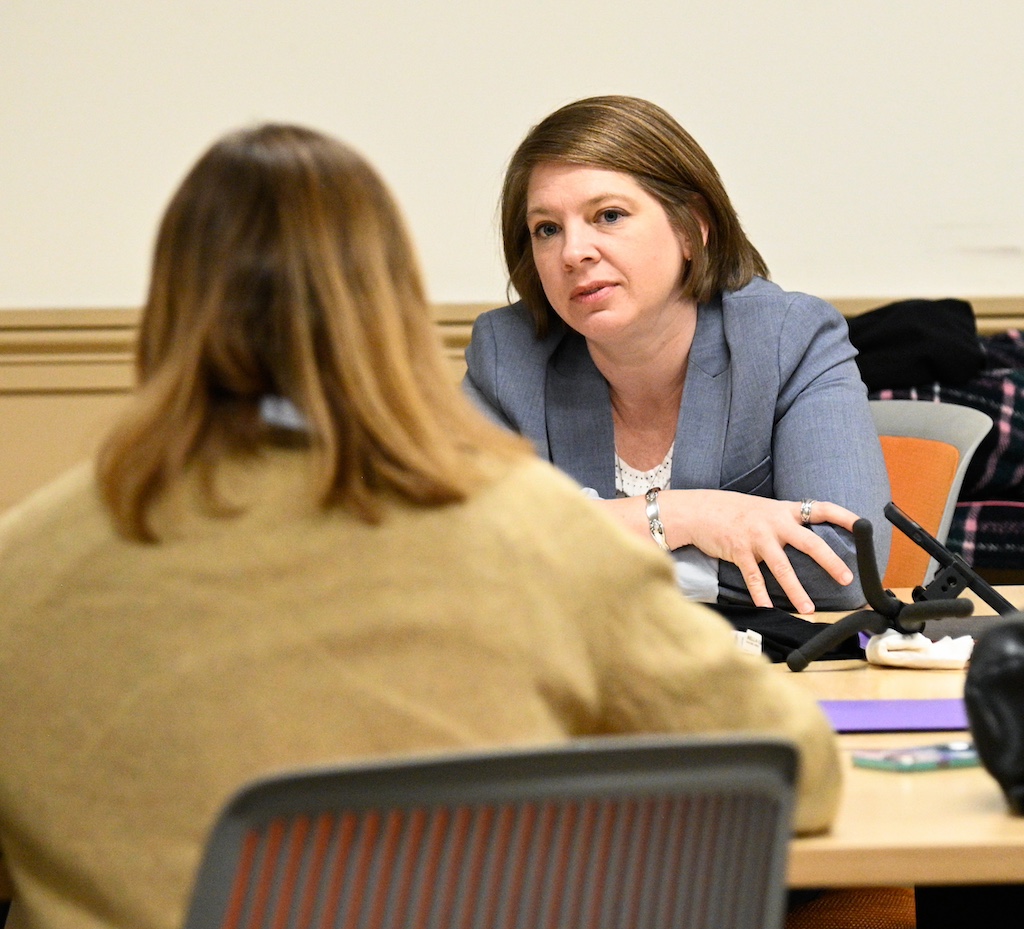 Two students sit across a table from each other at the UW MSIM student summit.