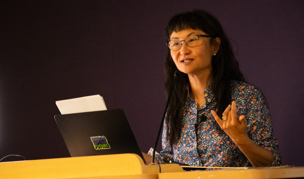 Dr. Wendy Hui Kyong Chun speaks at a podium.